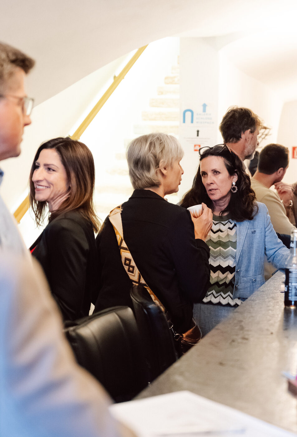 Mitglieder im Gespräch an der Bar im Foyer.